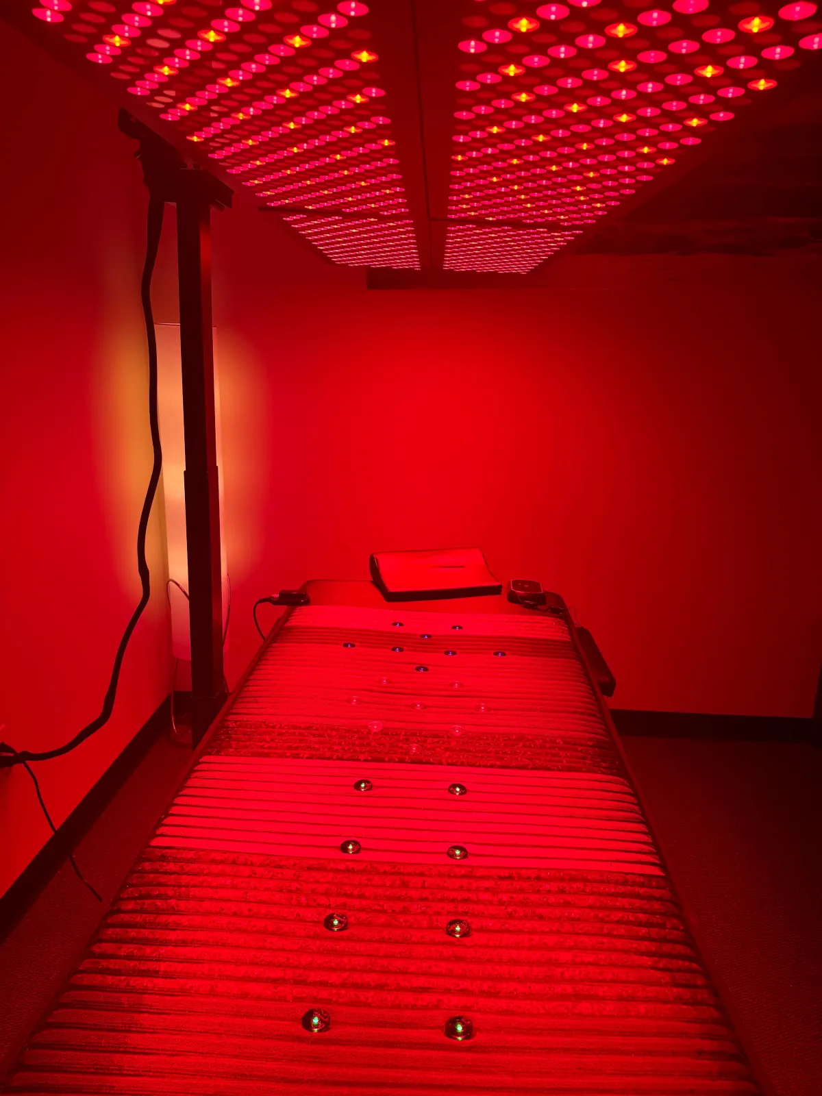 Woman receiving high-intensity red light therapy on medical-grade KoreStation panels with PEMF mat at Slim Down Solutions with PEMF mat